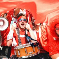 football-supporter-fans-cheering-with-flag-watching-soccer-cup-match-at-stadium-tribune-scaled-1